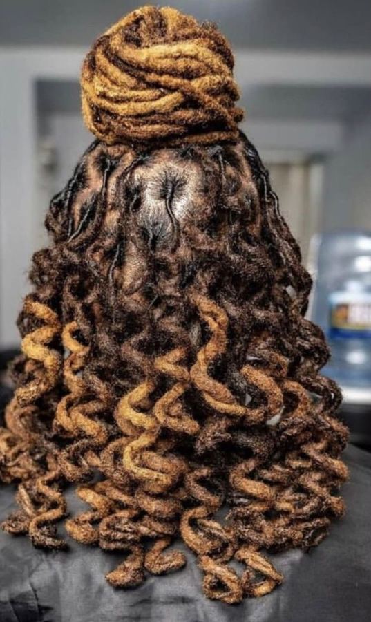 Long honey-blonde locs styled into a curled updo by J&K Dreadlock Studio